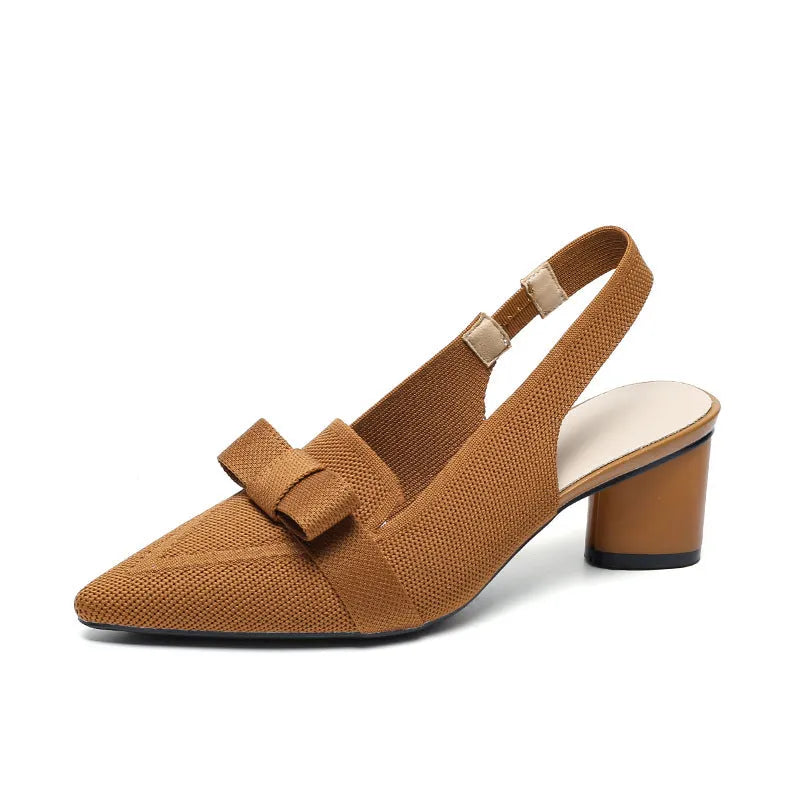 Women's closed toe high heel sandals with bow detail, ankle buckle strap, and pointed toe in a solid colour.