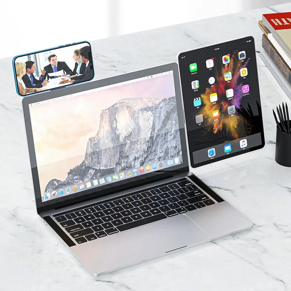 Black aluminium laptop phone holder with magnetic clip attached to laptop edge holding a smartphone