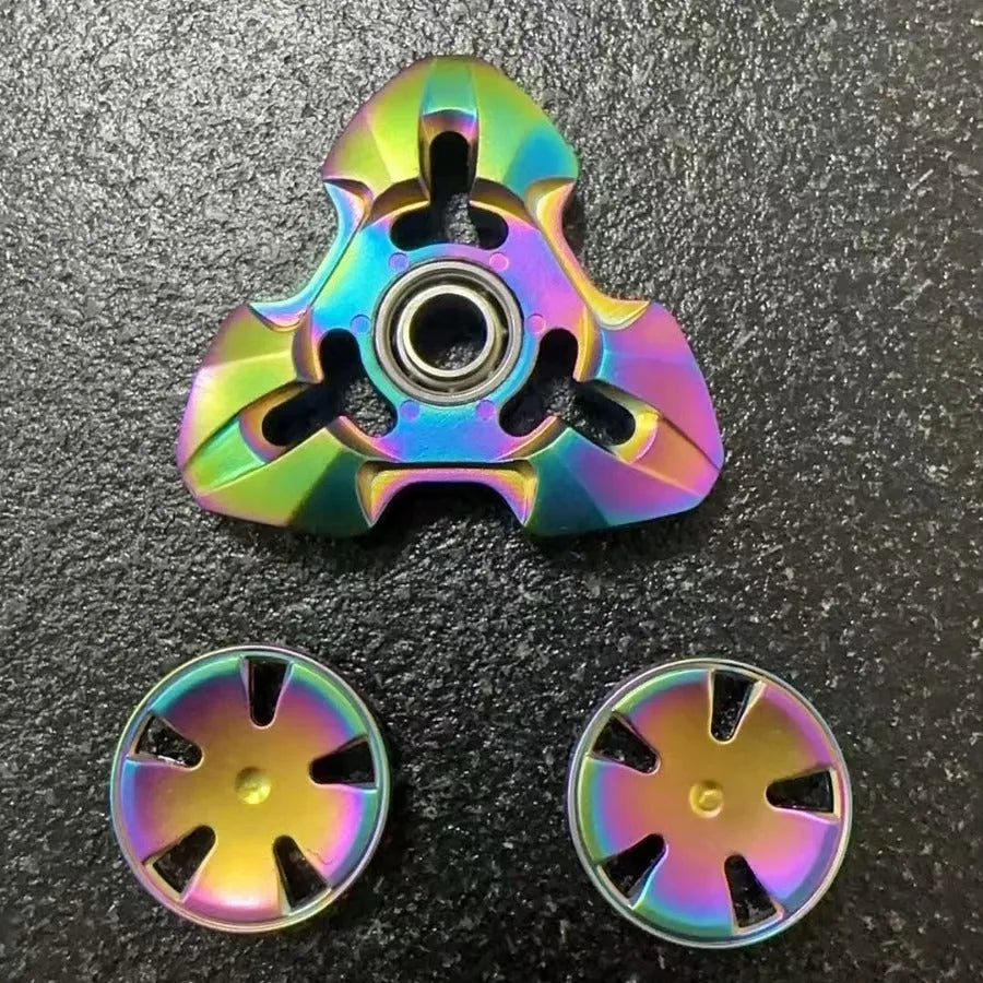 Alloy metal fingertip gyro decompression toy in gun metal colour, spinning on a surface.