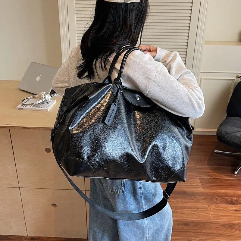 Women's black hand-carry travel bag with 36-55L capacity and polyester lining