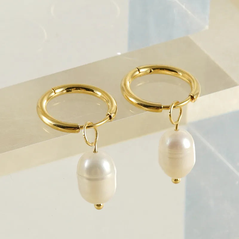 Gold geometric women's drop earrings with a pearl centre on hypoallergenic titanium steel posts.