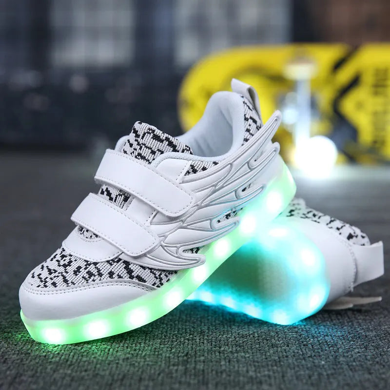 Children's plum red and white LED light-up sneakers showing USB charging port and colourful illumination.