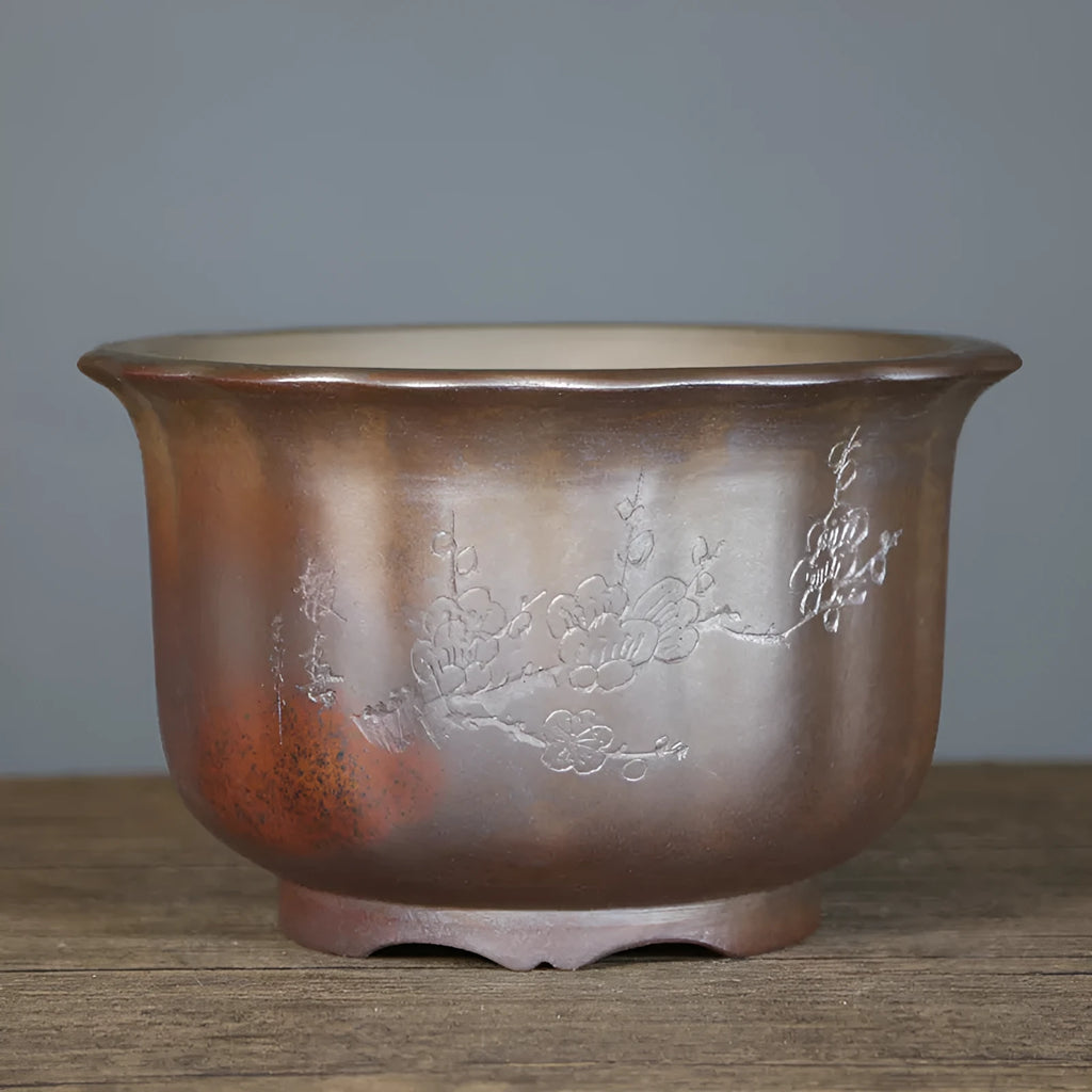 Indoor antique carved purple sand ceramic flowerpot for bonsai plants on a wooden surface.