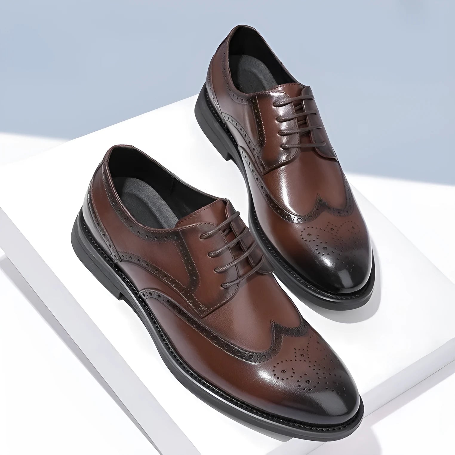 Men's black brogue leather shoes with wingtip perforations and lace-up closure on neutral background