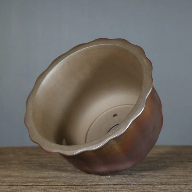 Indoor antique carved purple sand ceramic flowerpot for bonsai plants on a wooden surface.