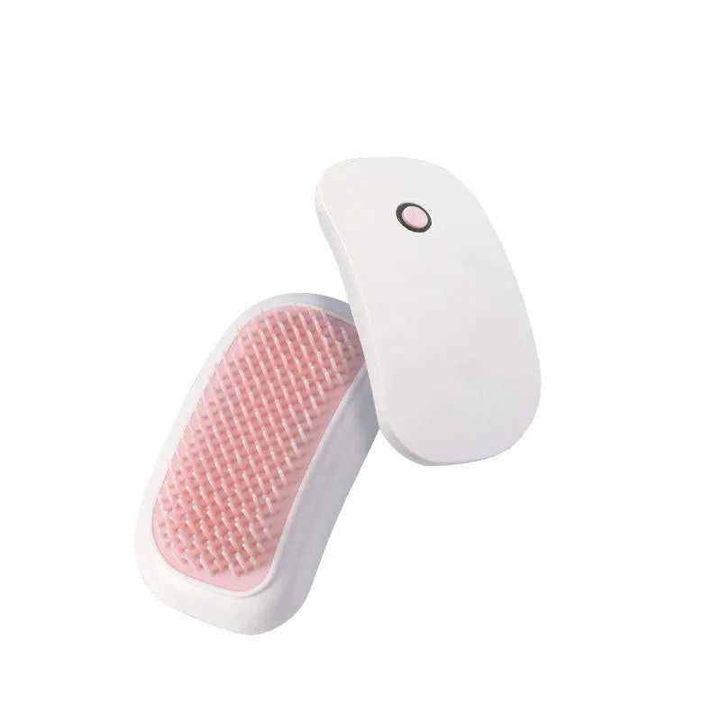 Pink handheld electric pet grooming brush with soft TPE teeth for cats and dogs.