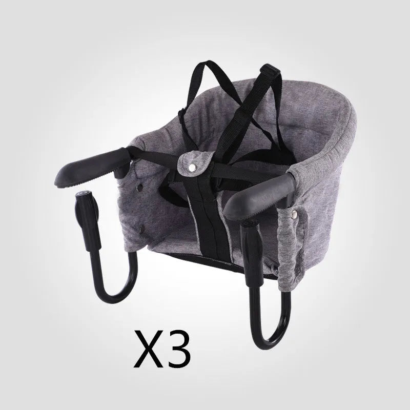 Portable baby dining seat with safety belt in blue, grey or red colours folded to show compact 42x36x7cm size