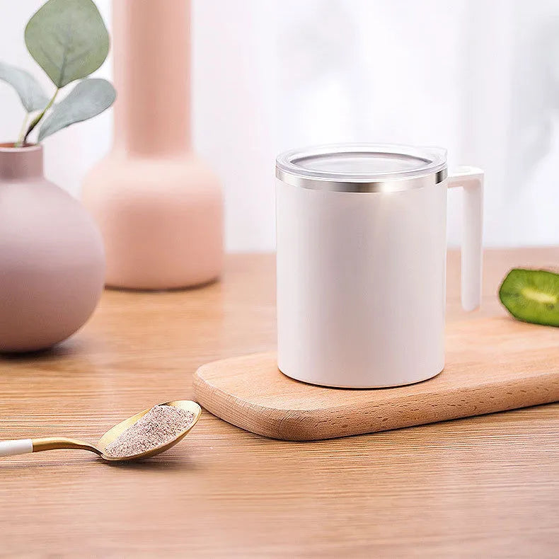 White automatic stirring coffee cup with rechargeable base on a table.