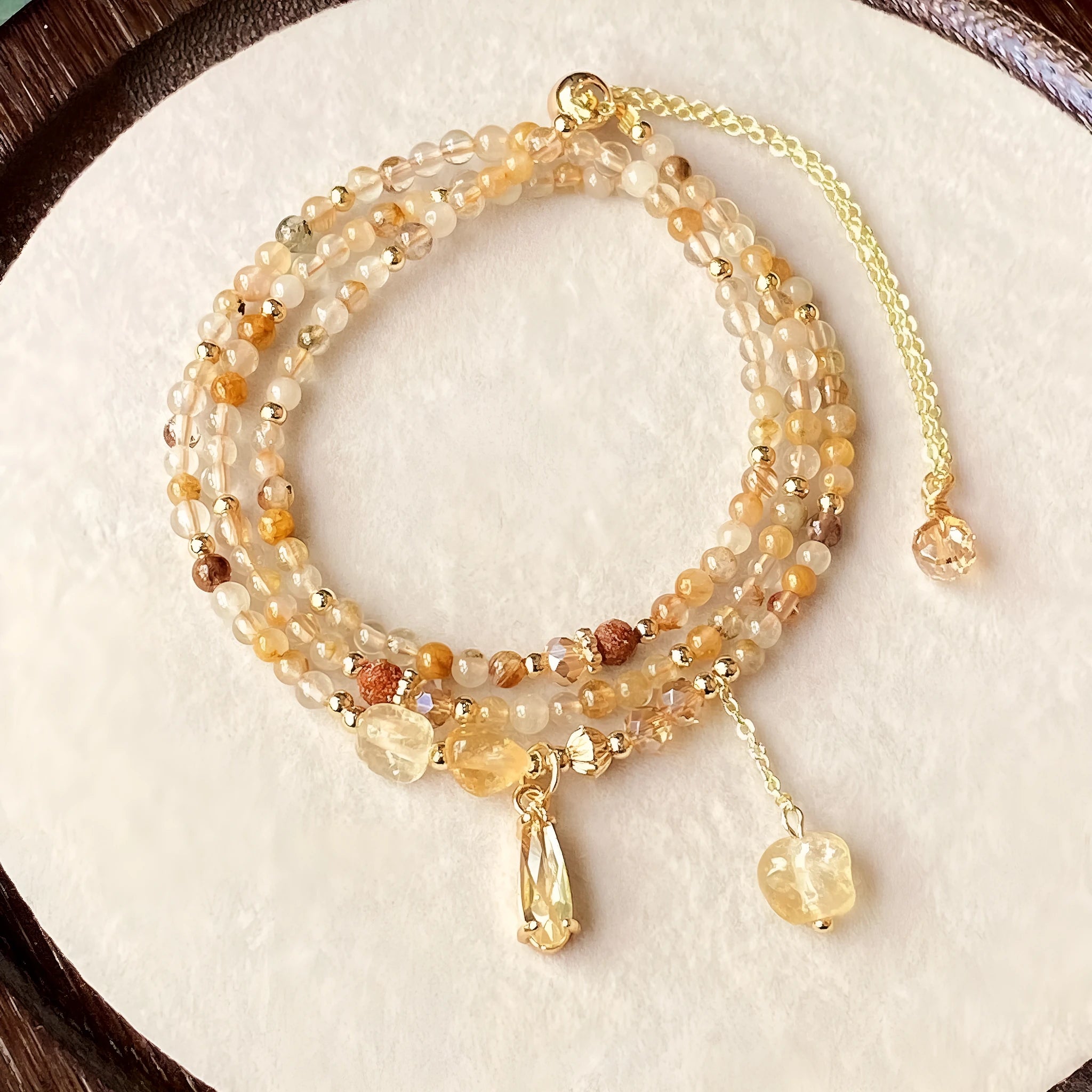 Gold tone women's bracelet with natural caramel coloured citrine crystal and Saturn decorative element