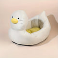 Blue duck-shaped fluffy pet bed for small dogs and cats on a wooden floor.