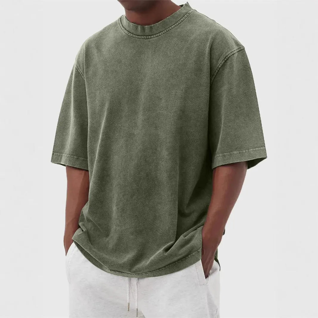 Man wearing a loose-fit, distressed army green pullover T-shirt with half sleeves.