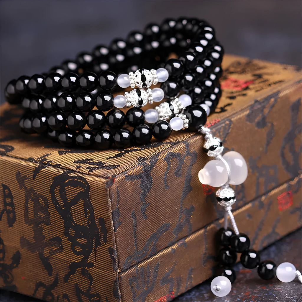 Natural black agate bracelet with 108 beads showing geometric shapes and numeric design elements