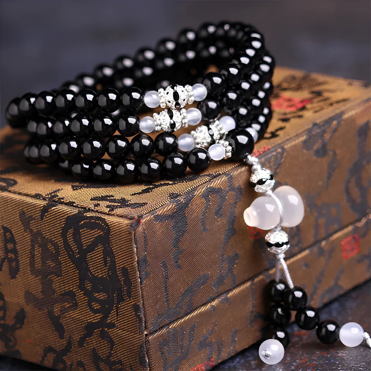 Natural black agate bracelet with 108 beads showing geometric shapes and numeric design elements