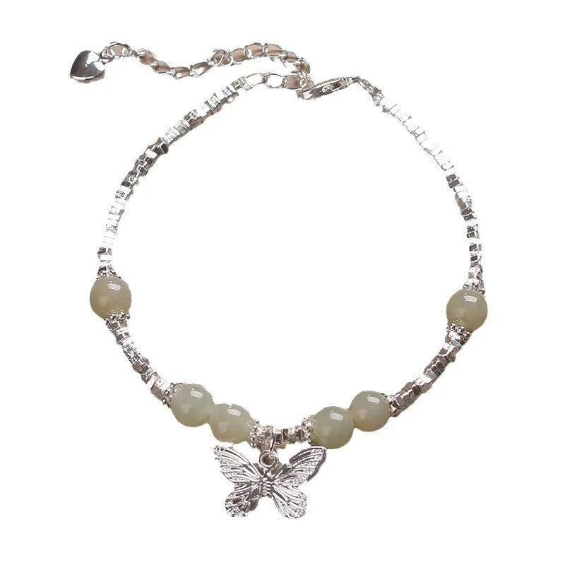 Hetian jade beads bracelet with silver butterfly pendant on a white background