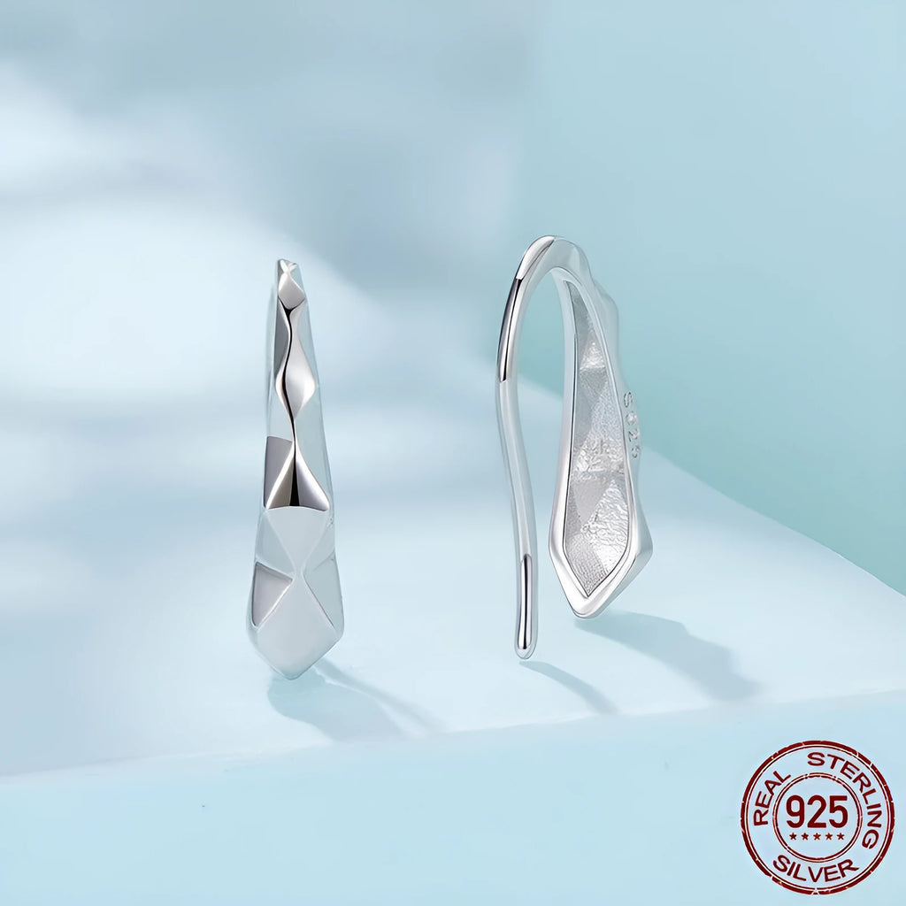 Close-up of S925 sterling silver rhombus earrings with diamond plaid pattern on a neutral background