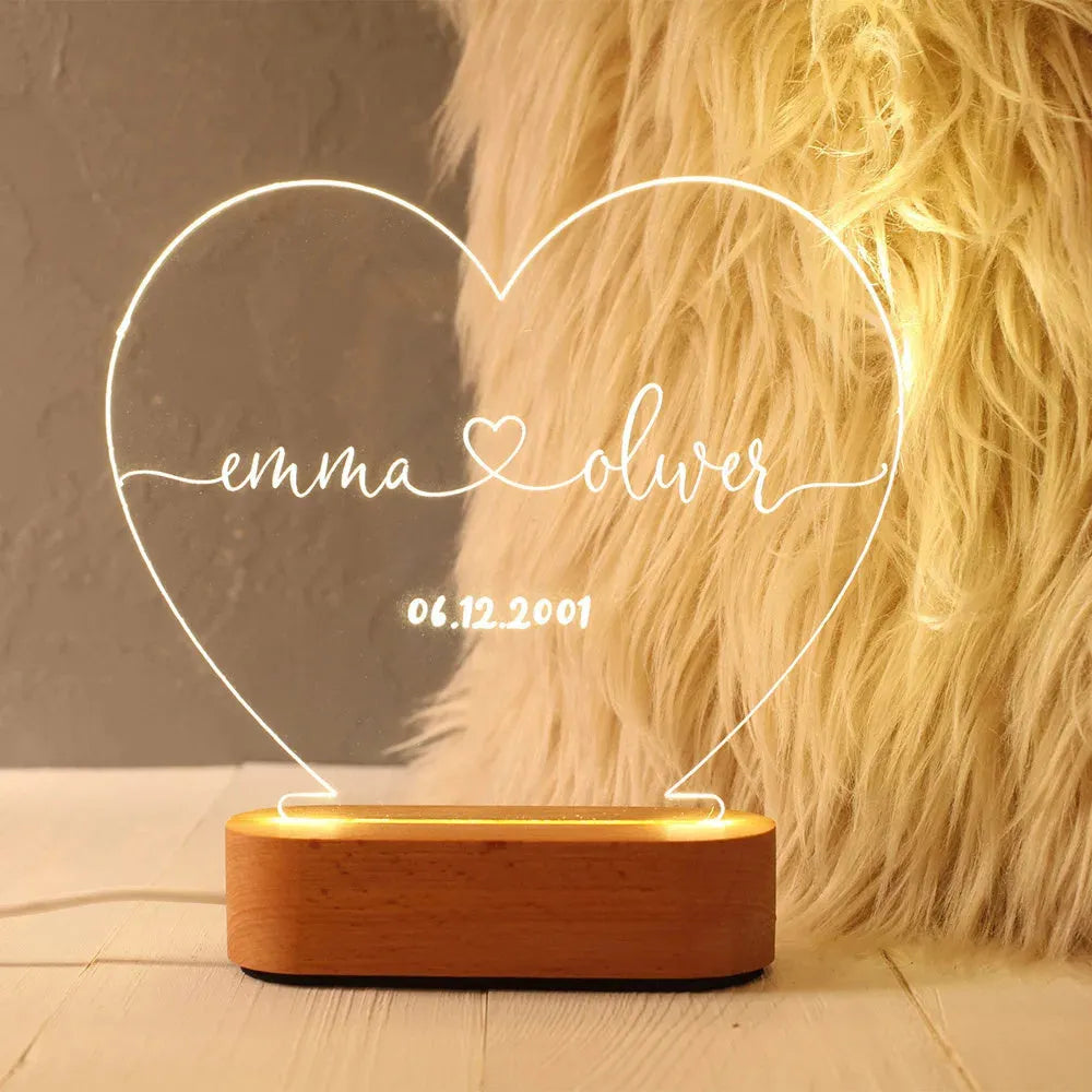 Custom acrylic night light with engraved names and date, lit by LED base.