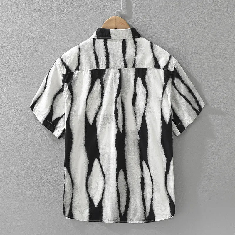 A man wearing a black and white striped loose-fit cotton cardigan-style short sleeve shirt.