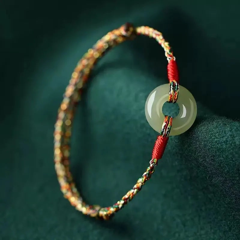 A woven bracelet with a peace buckle on a colourful braided rope.