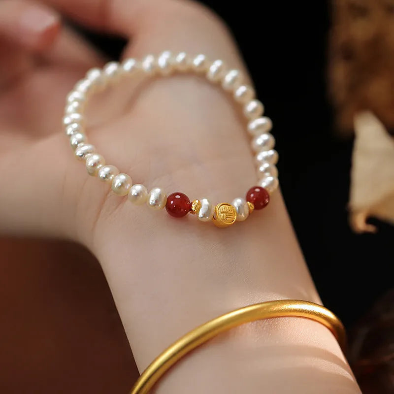 Natural freshwater pearl bracelet with Fu character charm on white background, silver chain, women's accessory