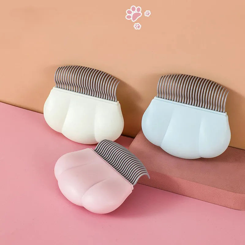 Paw Soft deshedding brush for pets in blue, pink, or white on a white background.