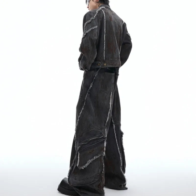 Black distressed raw-edge denim coat with padded shoulders and splash-dye gradient, paired with matching black pants.