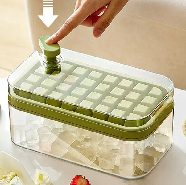 Green one-button press ice cube tray and storage box with lid on a kitchen counter