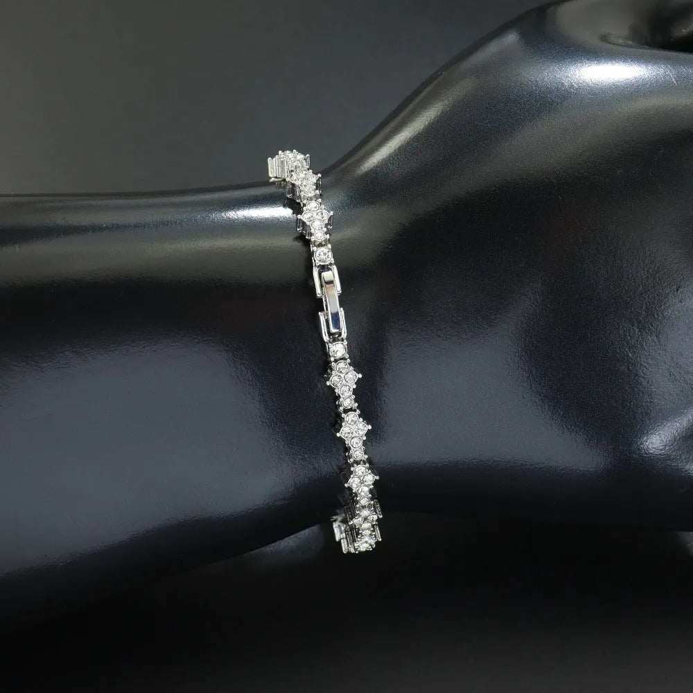 Flower-shaped cross tennis chain bracelet in gold alloy with diamond geometry pattern close-up