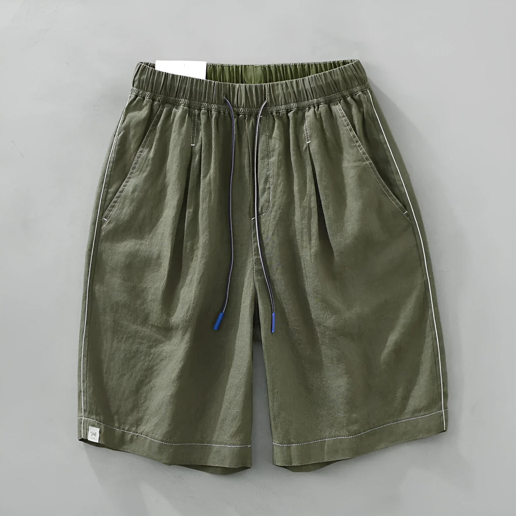 Men's loose fit linen shorts in green on a neutral background