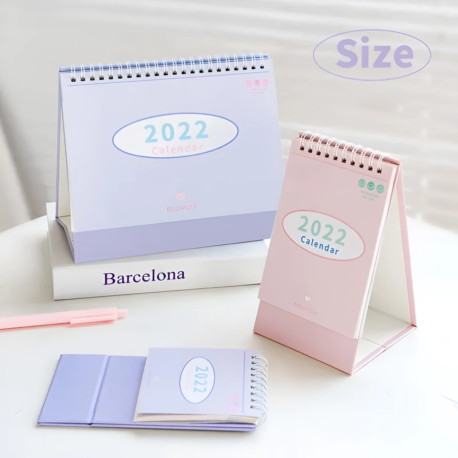 Cream coil-bound desk calendar for 2022, paper, Regular size, on a desk with month view visible