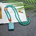 Close-up of a hand-woven turquoise mesh flower pendant on a ball bead necklace, adjustable from 71cm to 80cm.