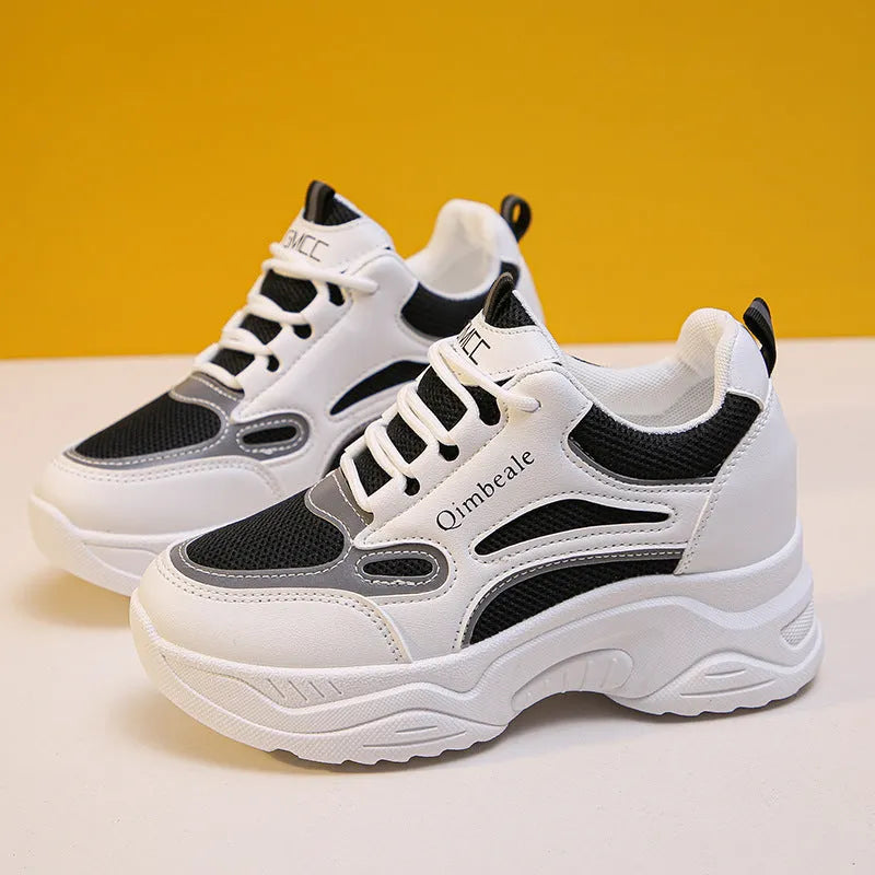 White height increasing dad shoes with mesh upper and wedge heel on a neutral background