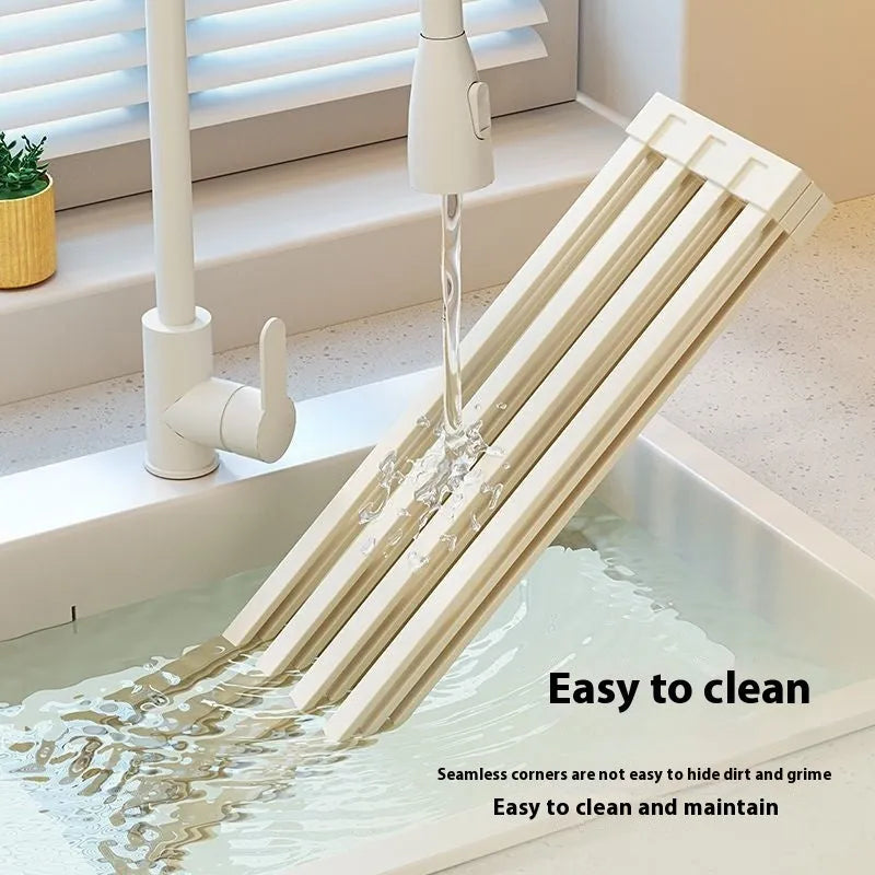 Milky white foldable stainless steel kitchen draining rack showing tri-fold mechanism