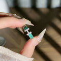 Mint green enamel ring with asymmetrical folded eight-point star design on copper band