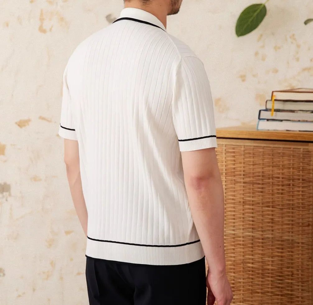 Slim fit black knitted polo shirt with a lapel collar and short sleeves on a hanger.