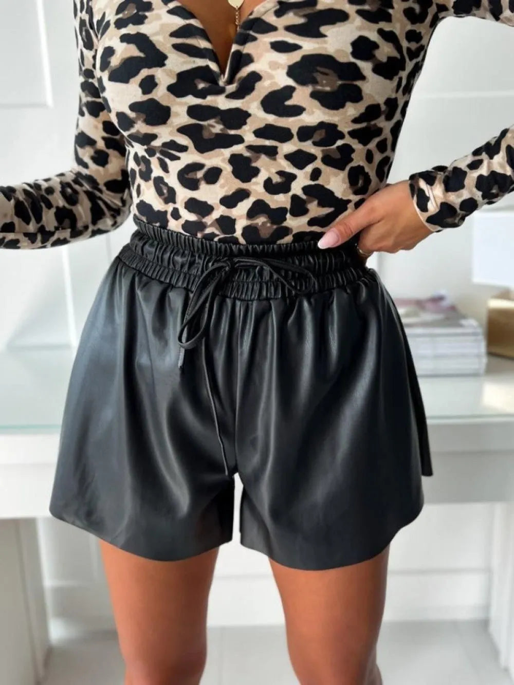 Women's black drawstring lace-up wide-leg casual shorts made of PU leather-look fabric.
