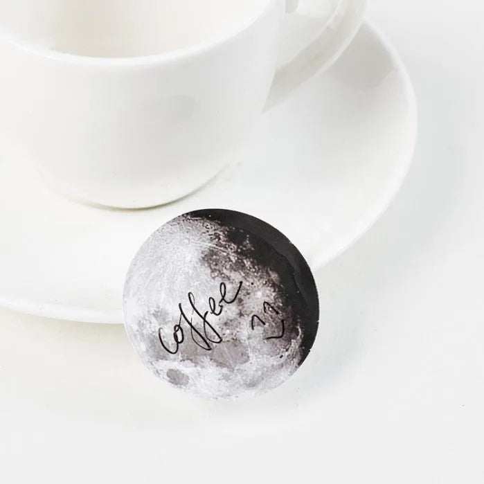 Box containing 45 black moon phase and planet calendar stickers on self-adhesive paper.