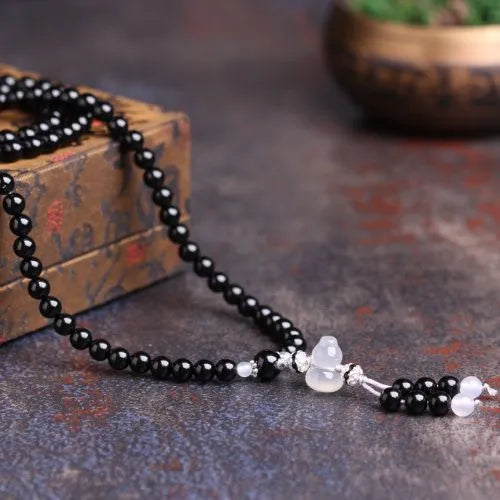 Natural black agate bracelet with 108 beads showing geometric shapes and numeric design elements