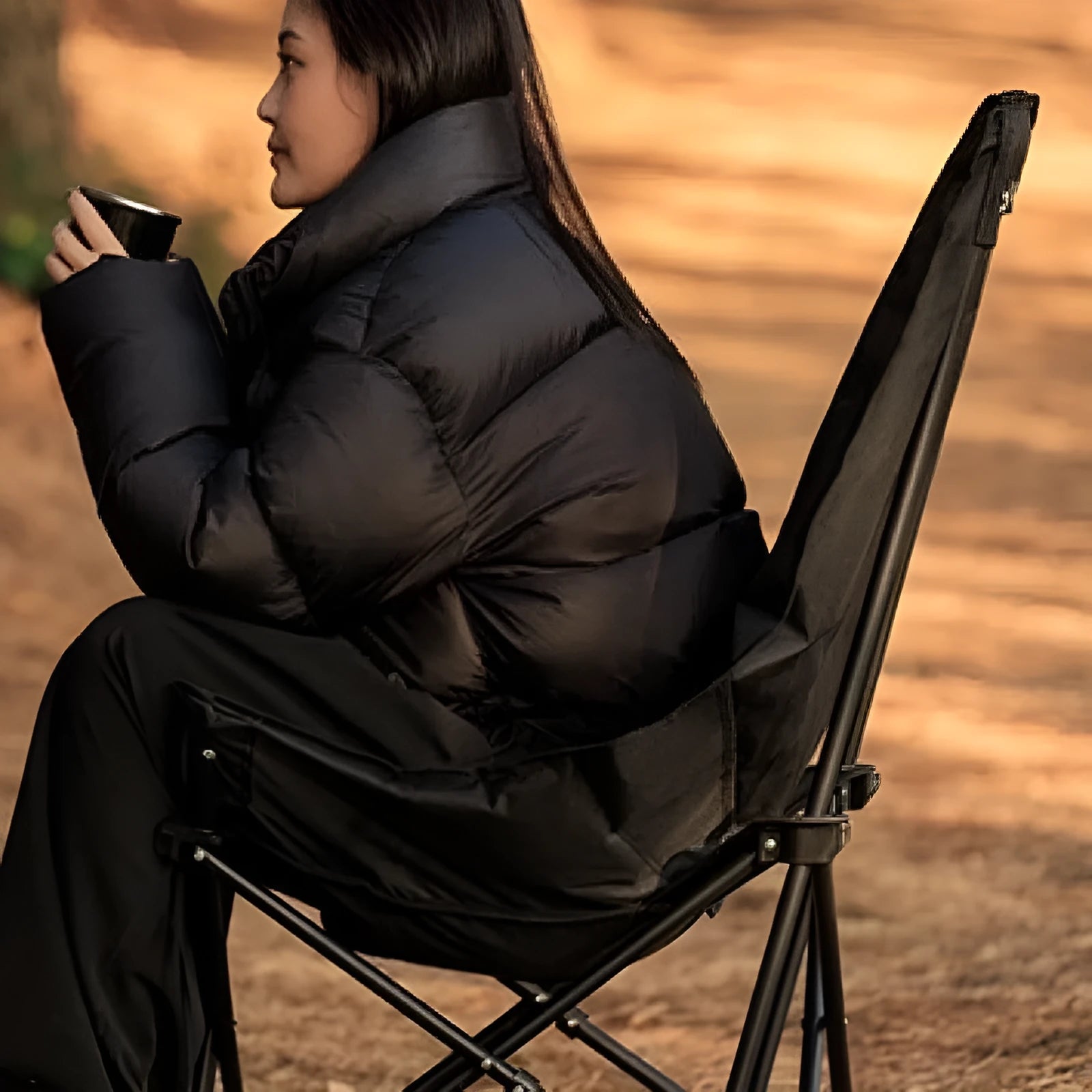 Night black portable folding camping recliner chair with a thickened seat in a moon chair style.