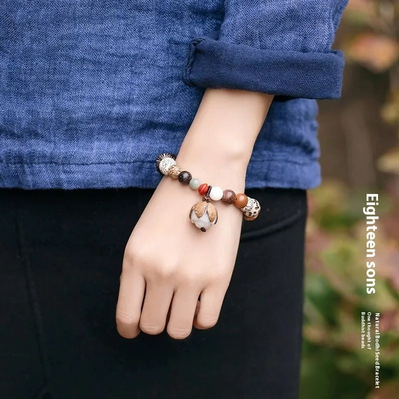 Handmade Bodhi seed bracelet with 18 natural beads on wrist, showing geometric national style design
