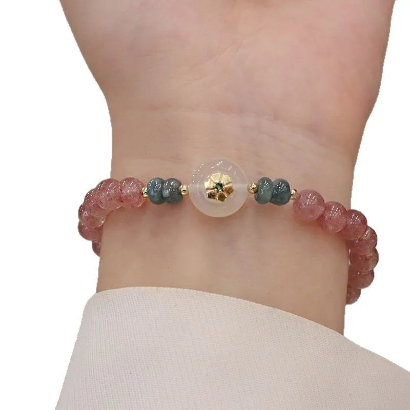 Women's strawberry quartz bracelet with blue water emerald jade pendant, geometric shapes, and traditional Chinese symbolism