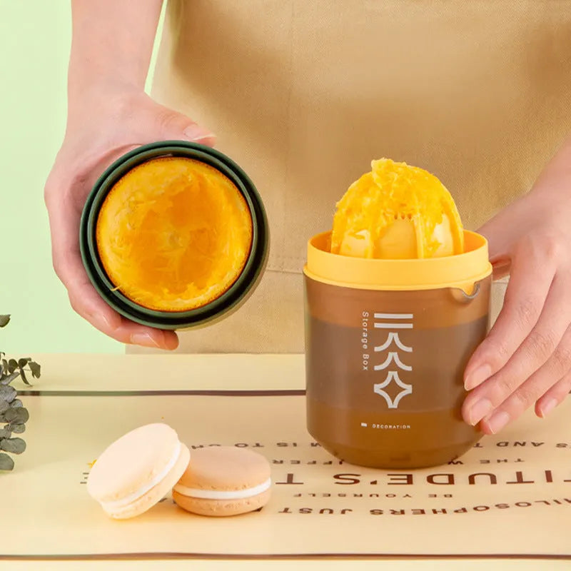 Green manual citrus juicer with lid on a kitchen countertop
