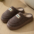 Men's grey suede slippers with a thickened sole on a wooden floor.