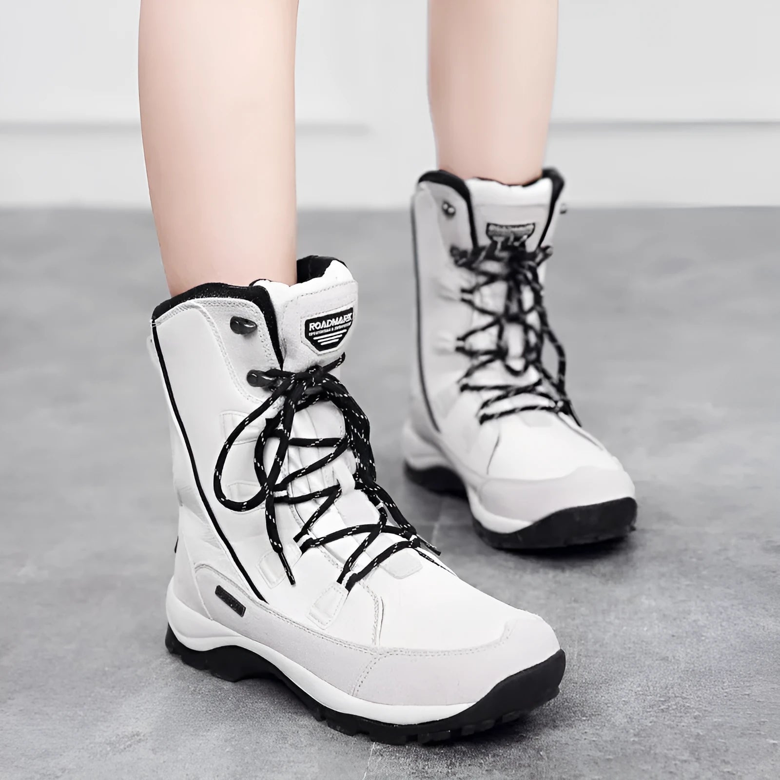 Women's black mid-calf snow boots with a round toe and genuine leather upper on a rubber sole.