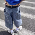 Men's blue washed denim cropped shorts with a high waist and zipper fly on a neutral background