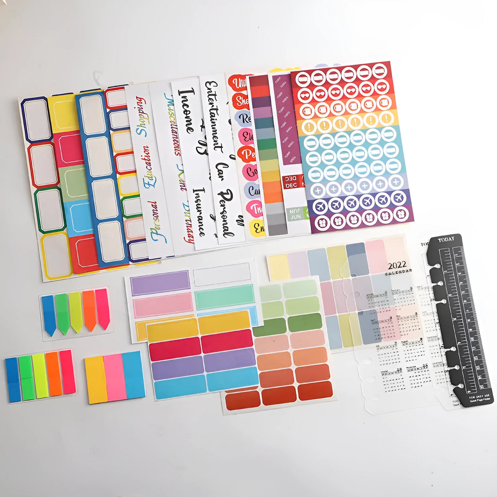Assortment of handwritten labels, grid stickers, A6 rulers, and coloured sticky notes on a white background.