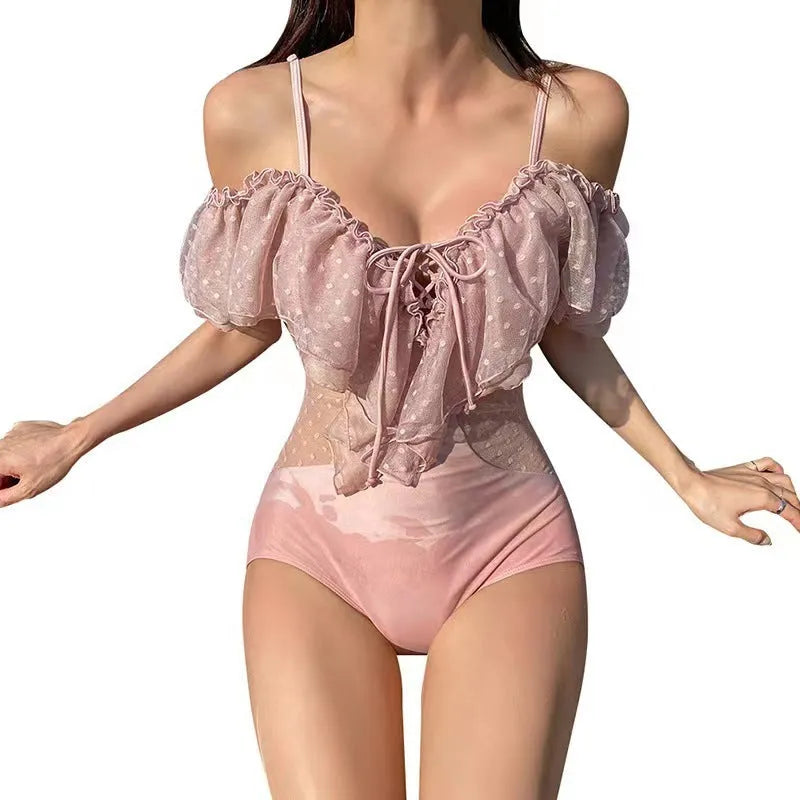 Pink solid colour women's one-piece nylon swimsuit on a hanger.