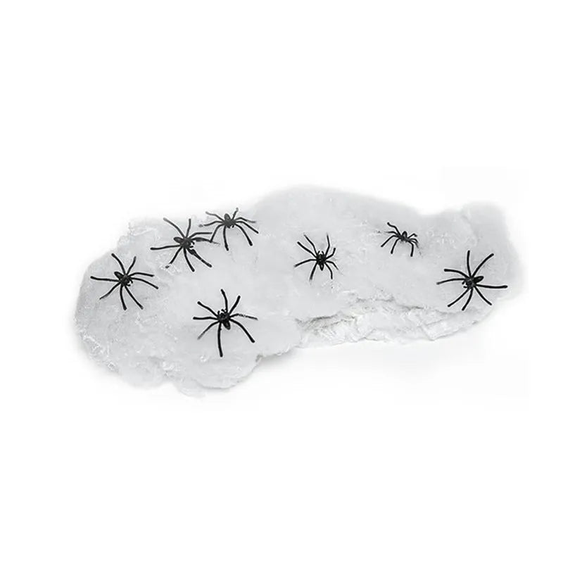 White cotton Halloween spider web decoration draped with plastic spiders for haunted house party decor.
