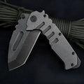 907 style outdoor folding knife with D2 steel blade, 9 cm blade, black handle, closed position on grey background