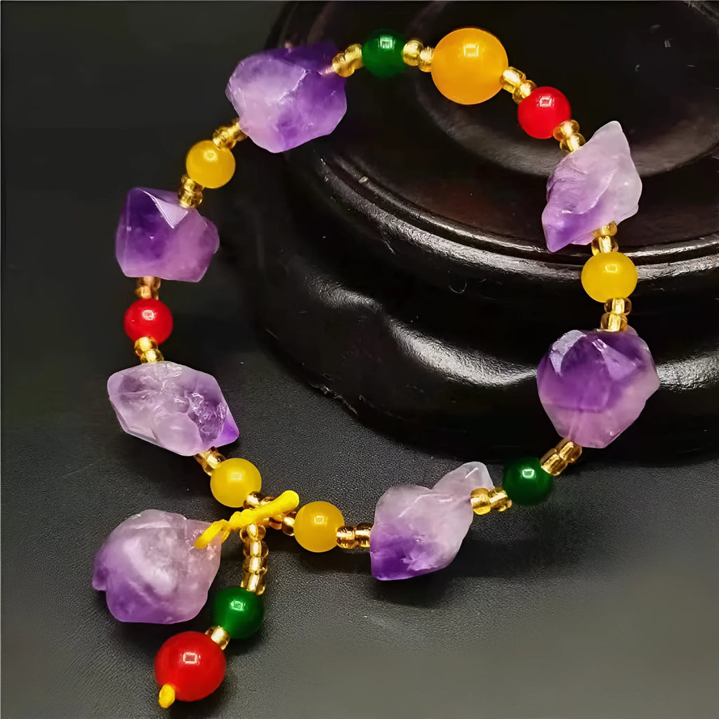 Women's amethyst bead bracelet with a Chinese fu character charm on a white background.