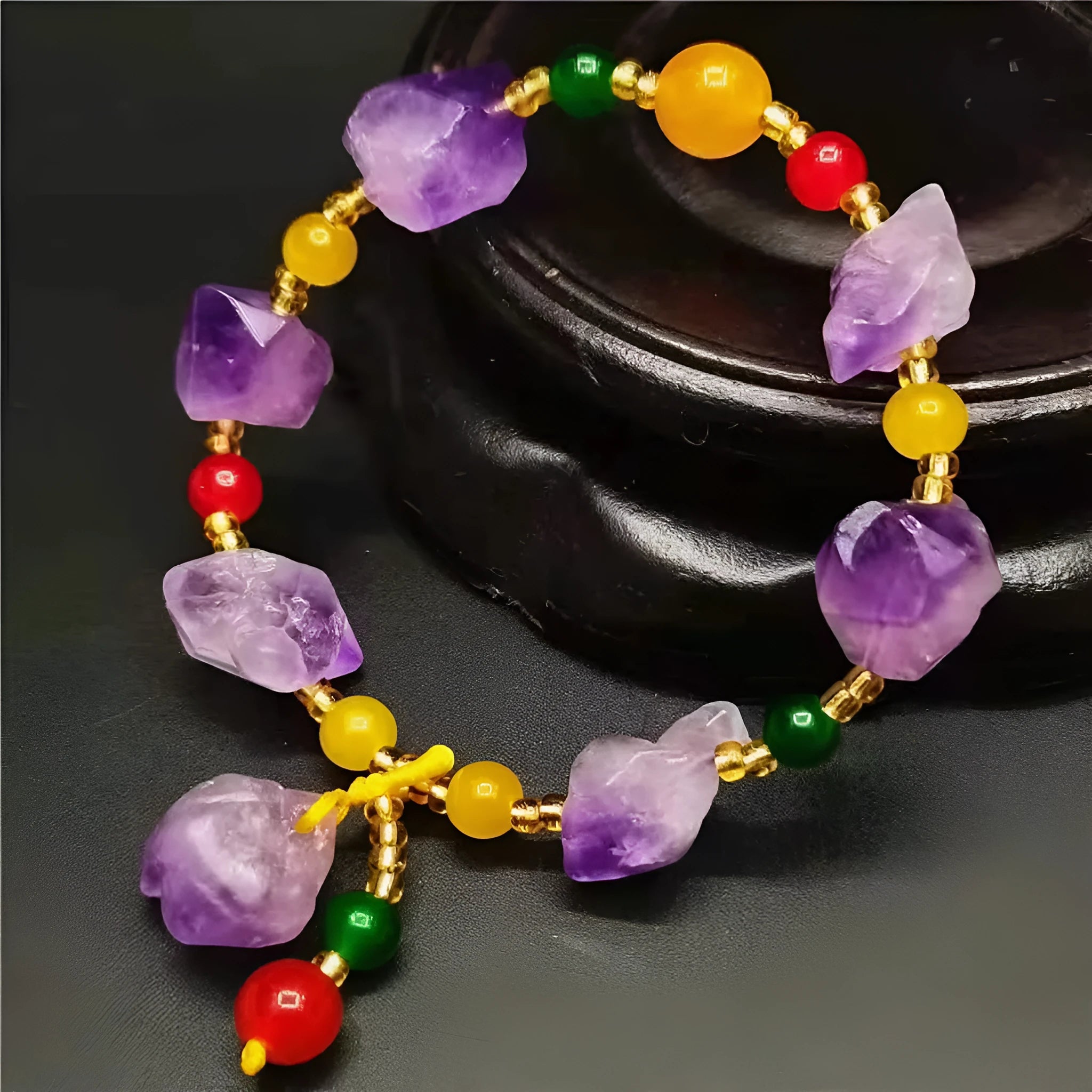 Women's amethyst bead bracelet with a Chinese fu character charm on a white background.